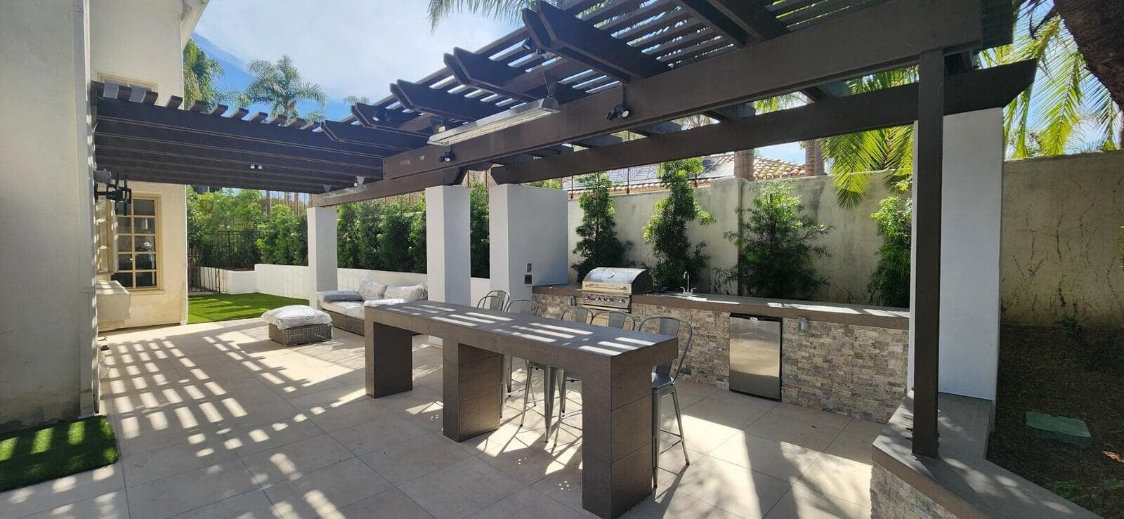 Hillside backyard built in sequence — retaining and drainage first, then hardscape, structures, and lighting