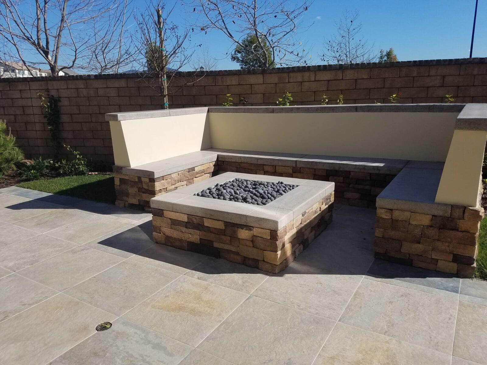 Stacked-stone gas fire pit with bench seating