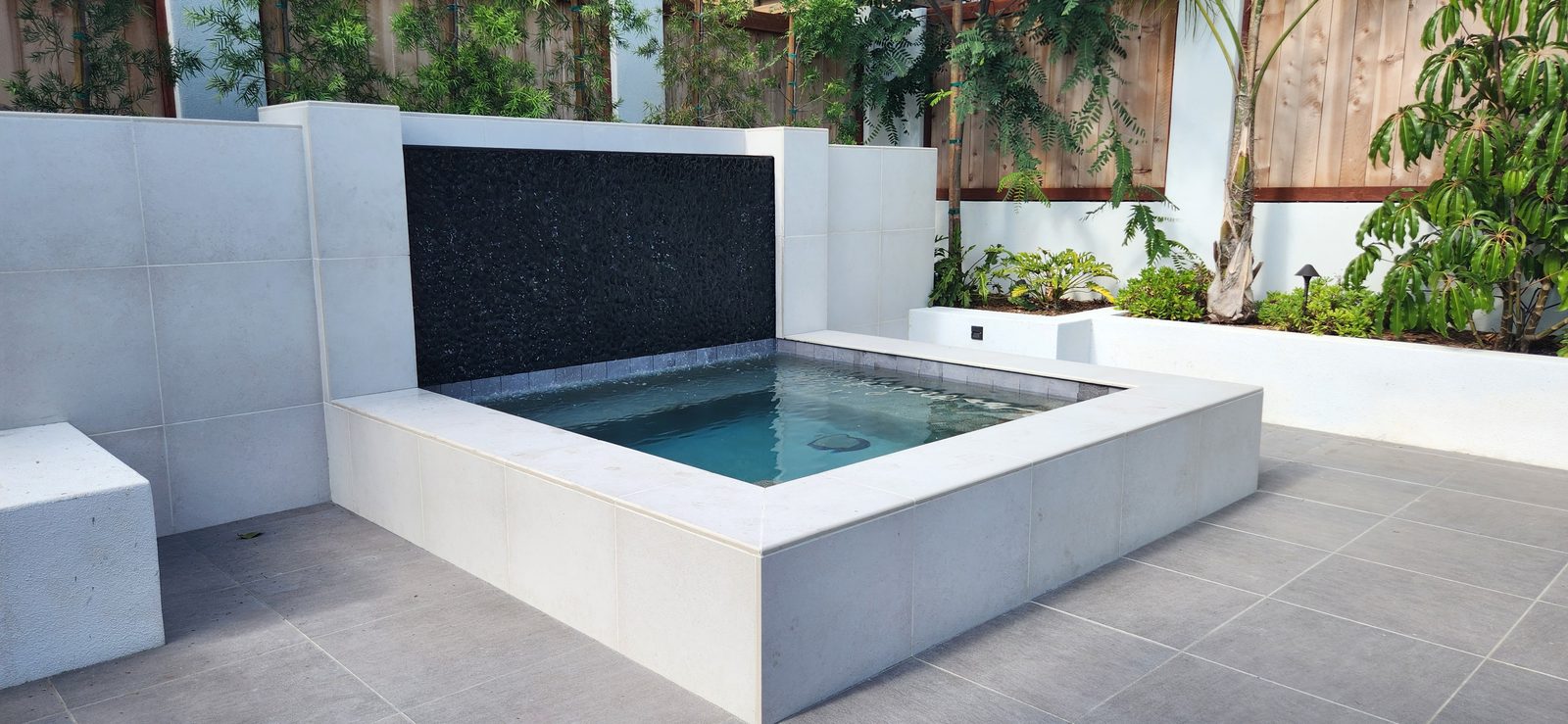 Pondless stone water feature with a planted surround, San Diego County